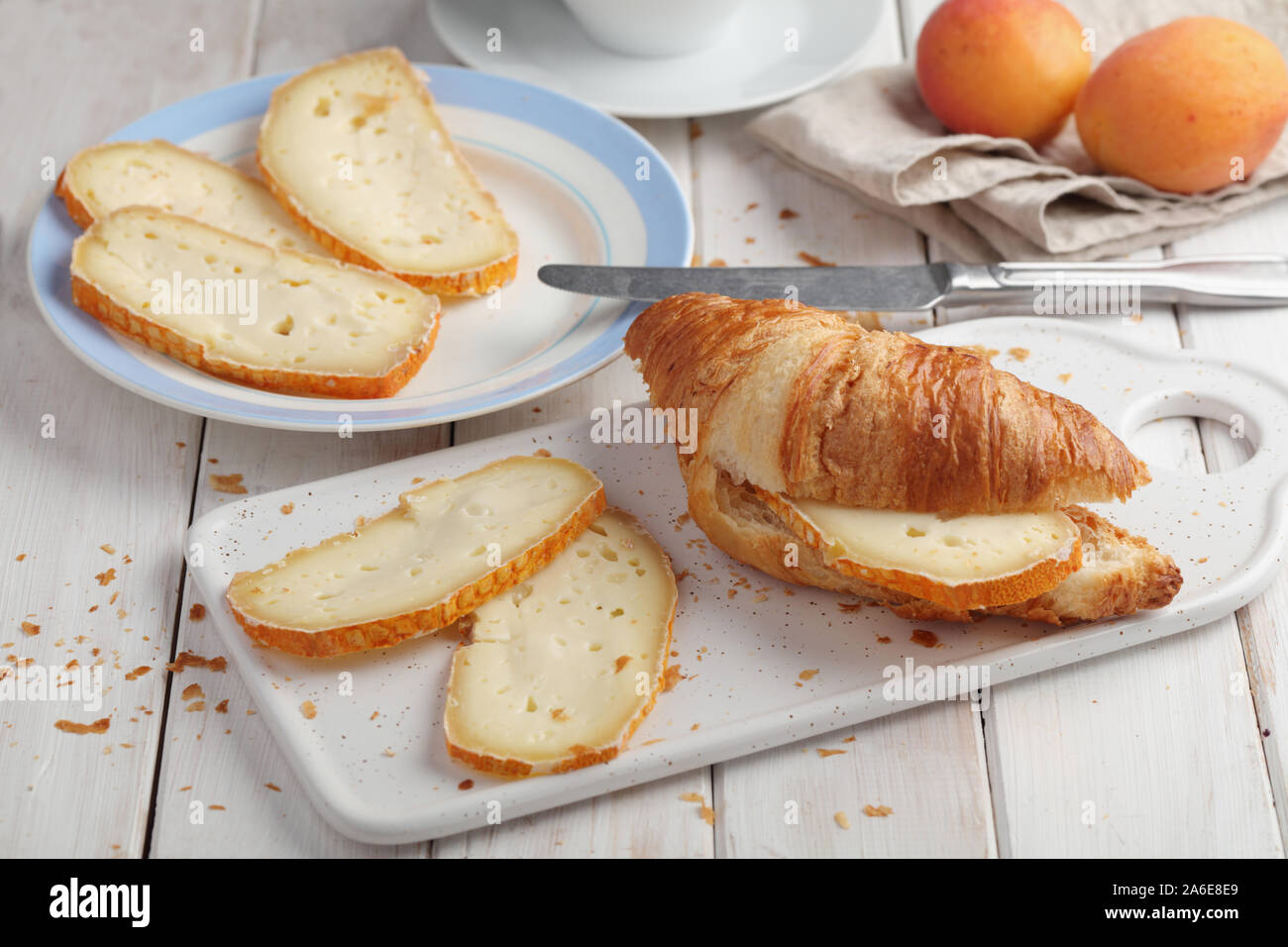 Croissant sandwich con formaggio a fette su un tavolo rustico Foto Stock