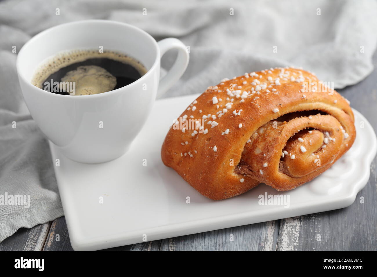 Torta svedese alla cannella e una tazza di caffè nero Foto Stock