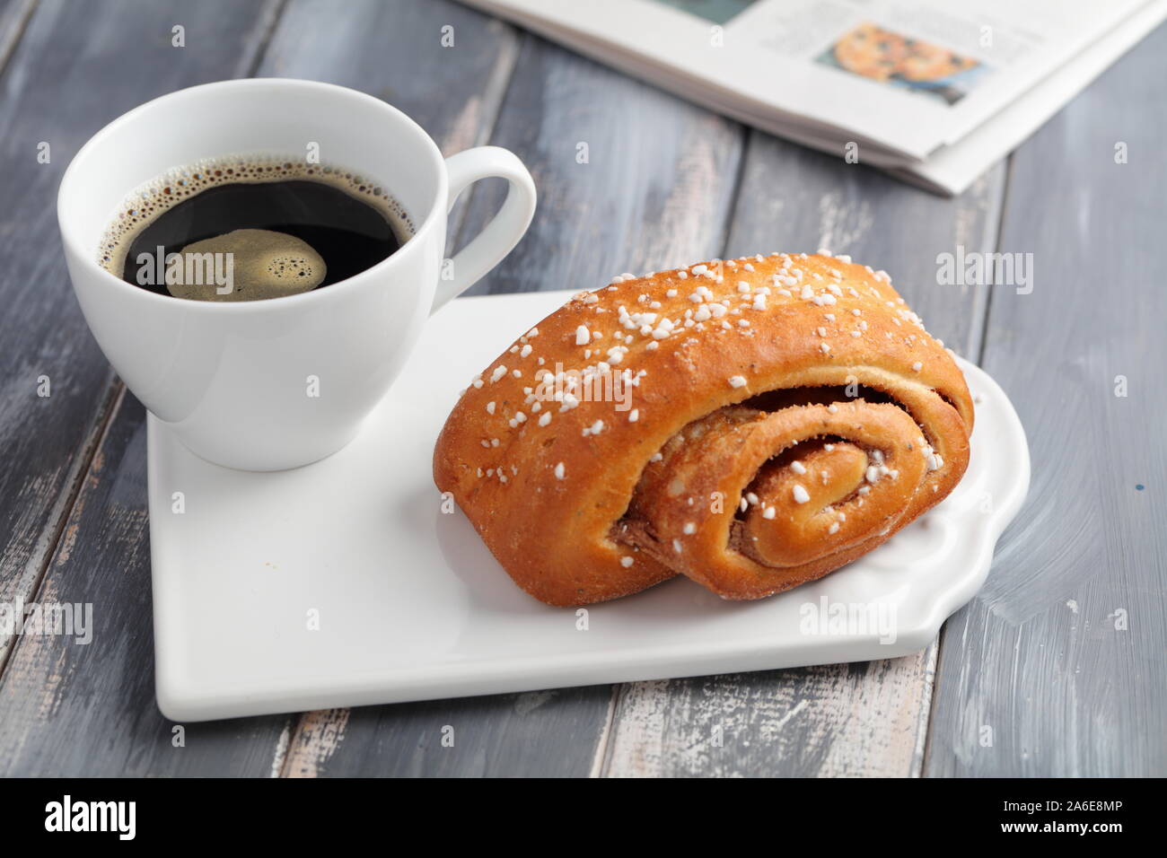 Torta svedese alla cannella e una tazza di caffè nero Foto Stock