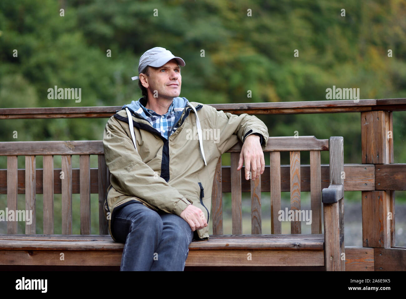 Uomo in abbigliamento casual seduta su una panchina Foto Stock