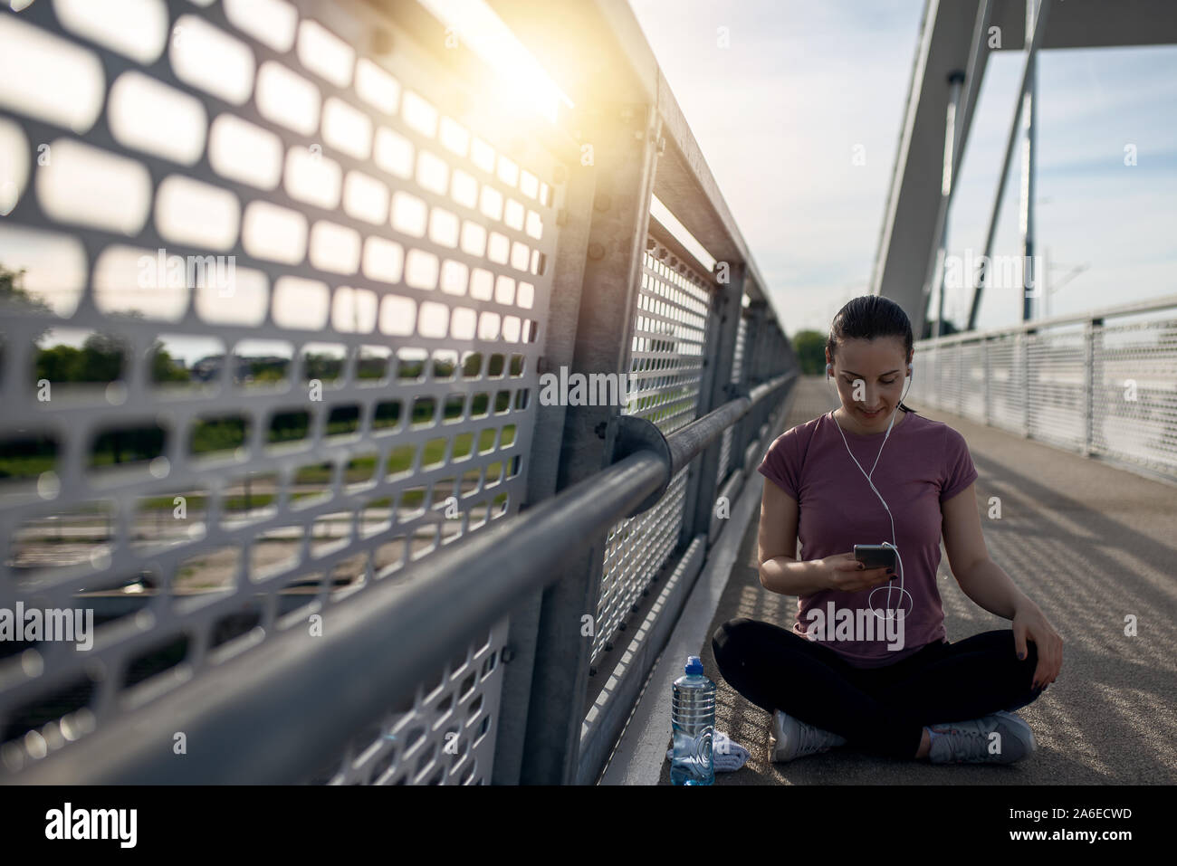 Esercizio al tramonto con belle, sport donna. Donna fitness jogging, l'allenamento il concetto di benessere. Femminile ascoltare musica durante il jogging Foto Stock