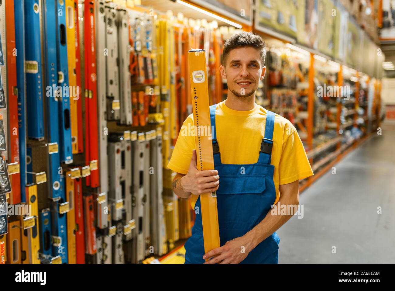 Builder maschio con livello di edificio in negozio di ferramenta Foto Stock
