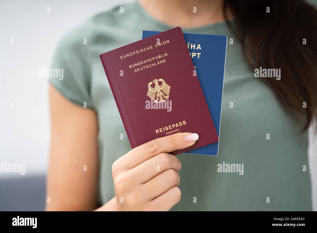 Donna che mantiene due passaporti. In Ucraina e in tedesco Foto Stock