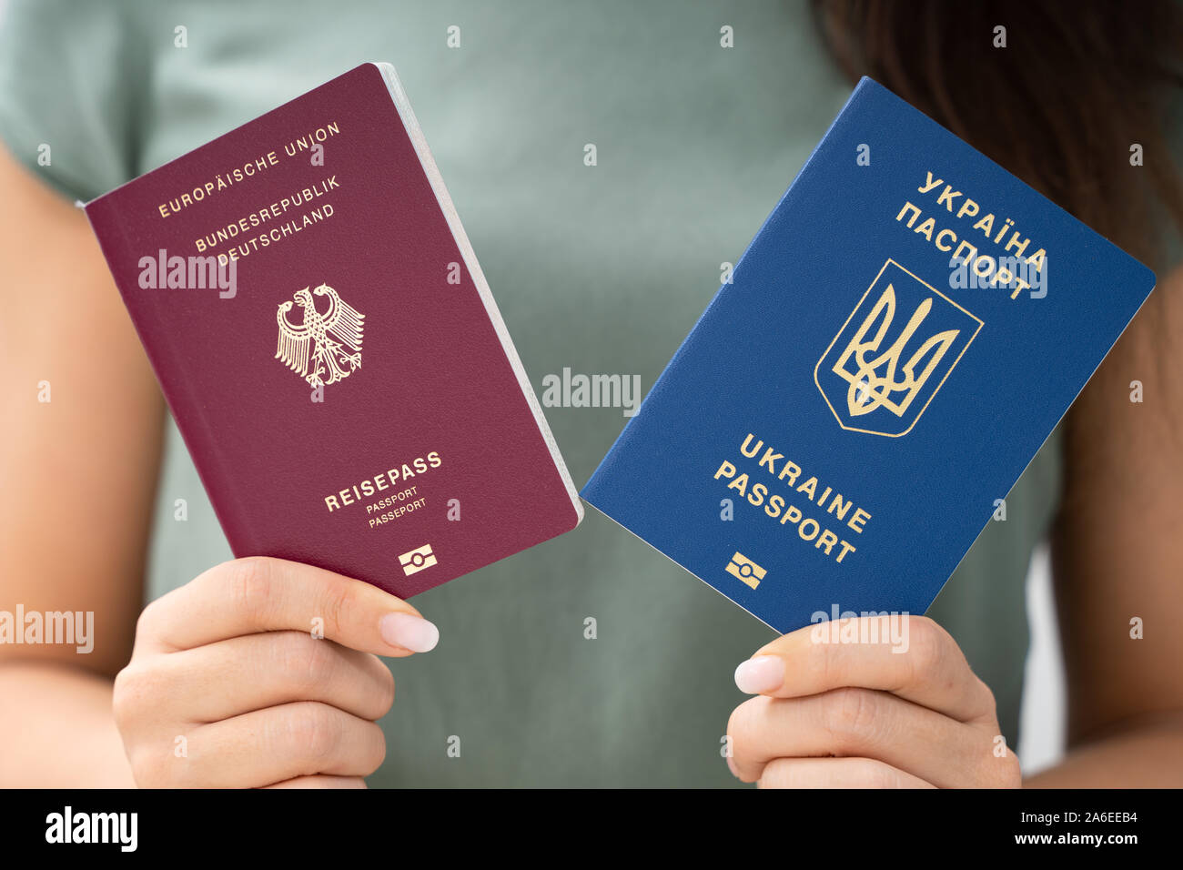 Donna che mantiene due passaporti. In Ucraina e in tedesco Foto Stock