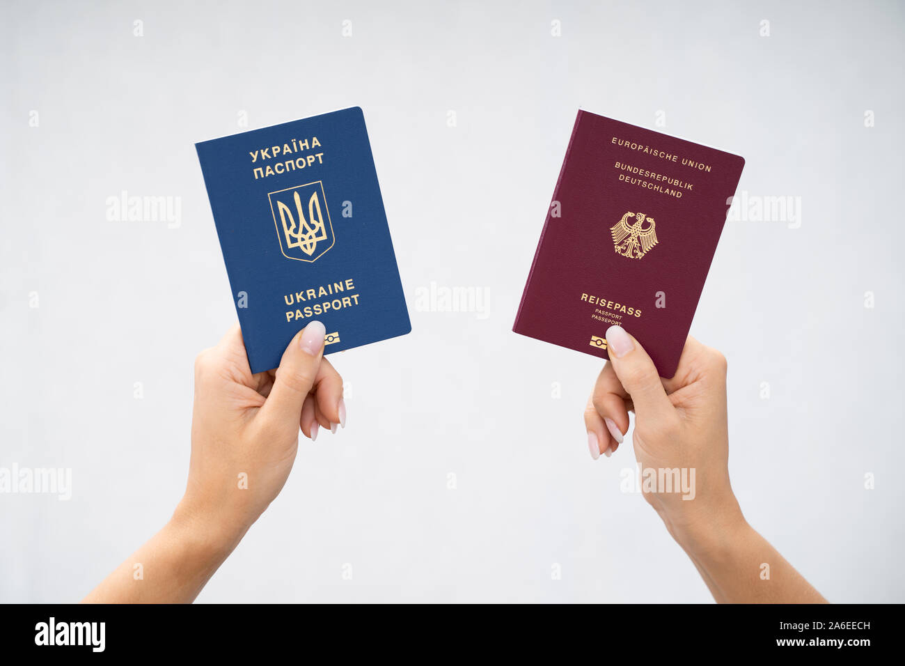 Donna che mantiene due passaporti. In Ucraina e in tedesco Foto Stock