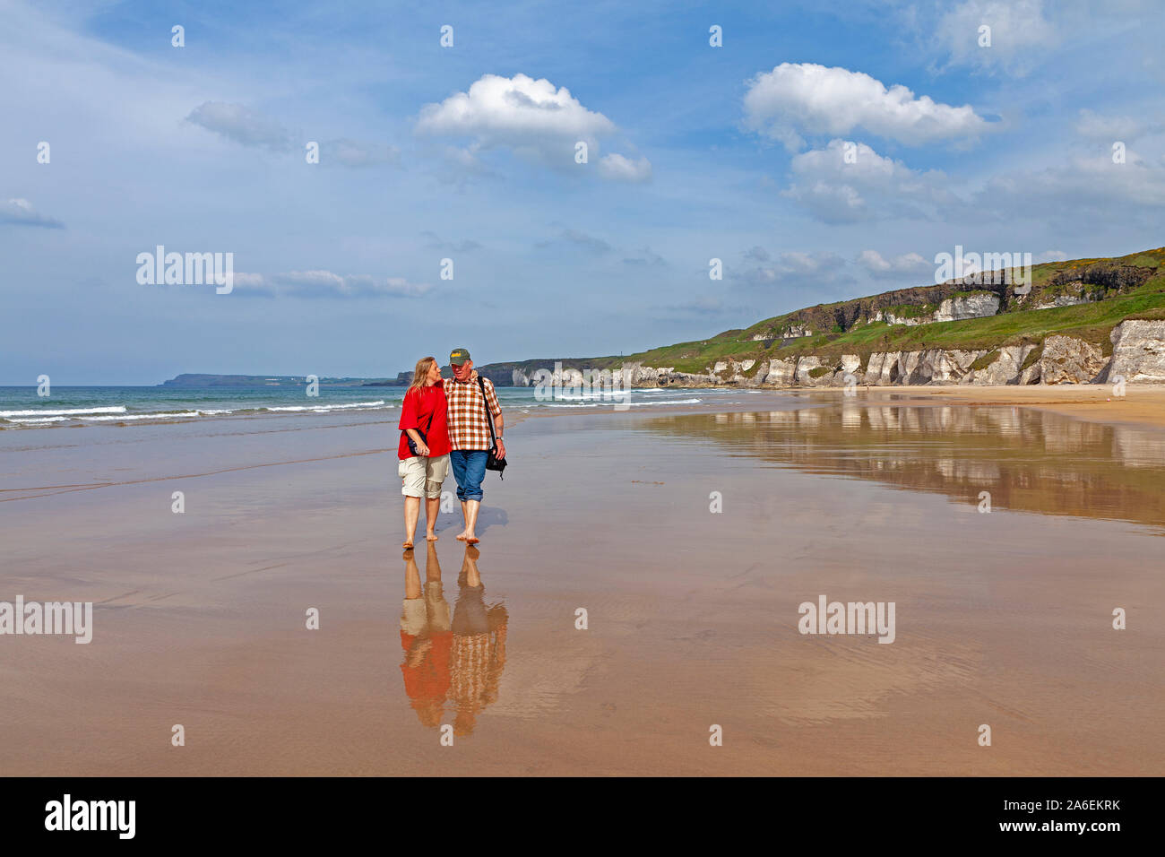 Un giovane sta camminando lungo una spiaggia vicino Portrush nella contea di Antrim, Irlanda del Nord. Foto Stock