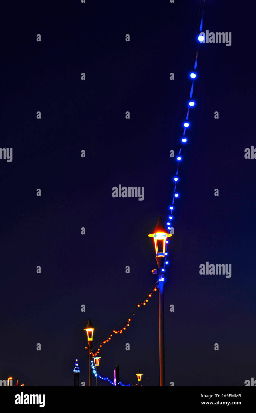 Stringa di blu delle lampadine della luce tra i lampioni sul lungomare di Blackpool durante le luminarie annuale Foto Stock