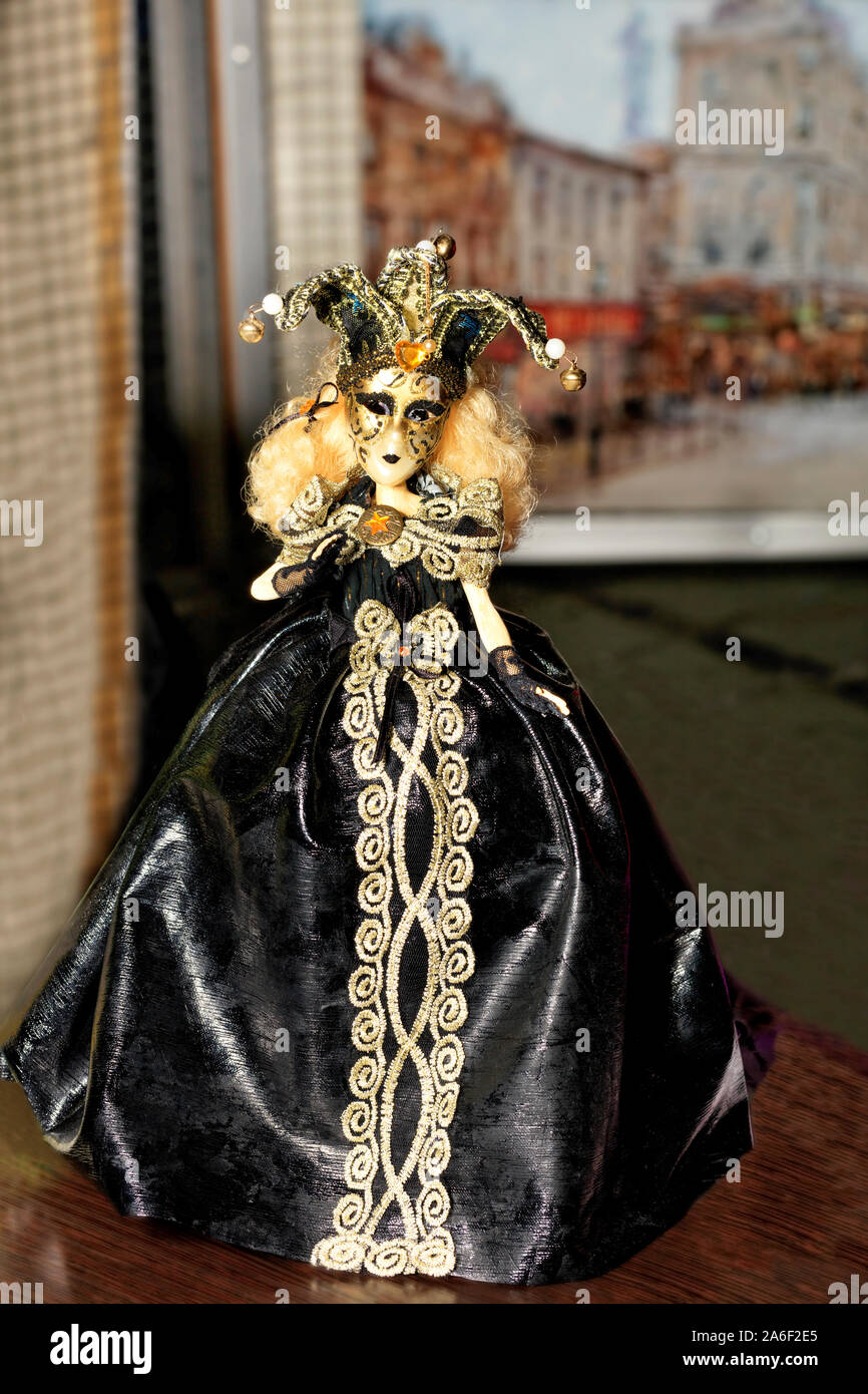 La bambola di giovani Halloween strega in un nero abito da sera con dark make-up sul suo viso e la diffusione di un cappello con un dritto hat sul suo capo. Foto Stock