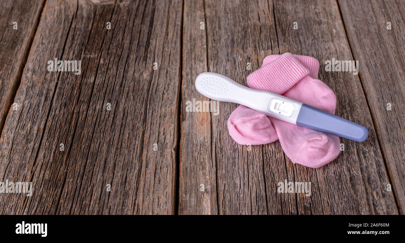 Test di gravidanza come una vita ancora su un sfondo di legno. Foto Stock