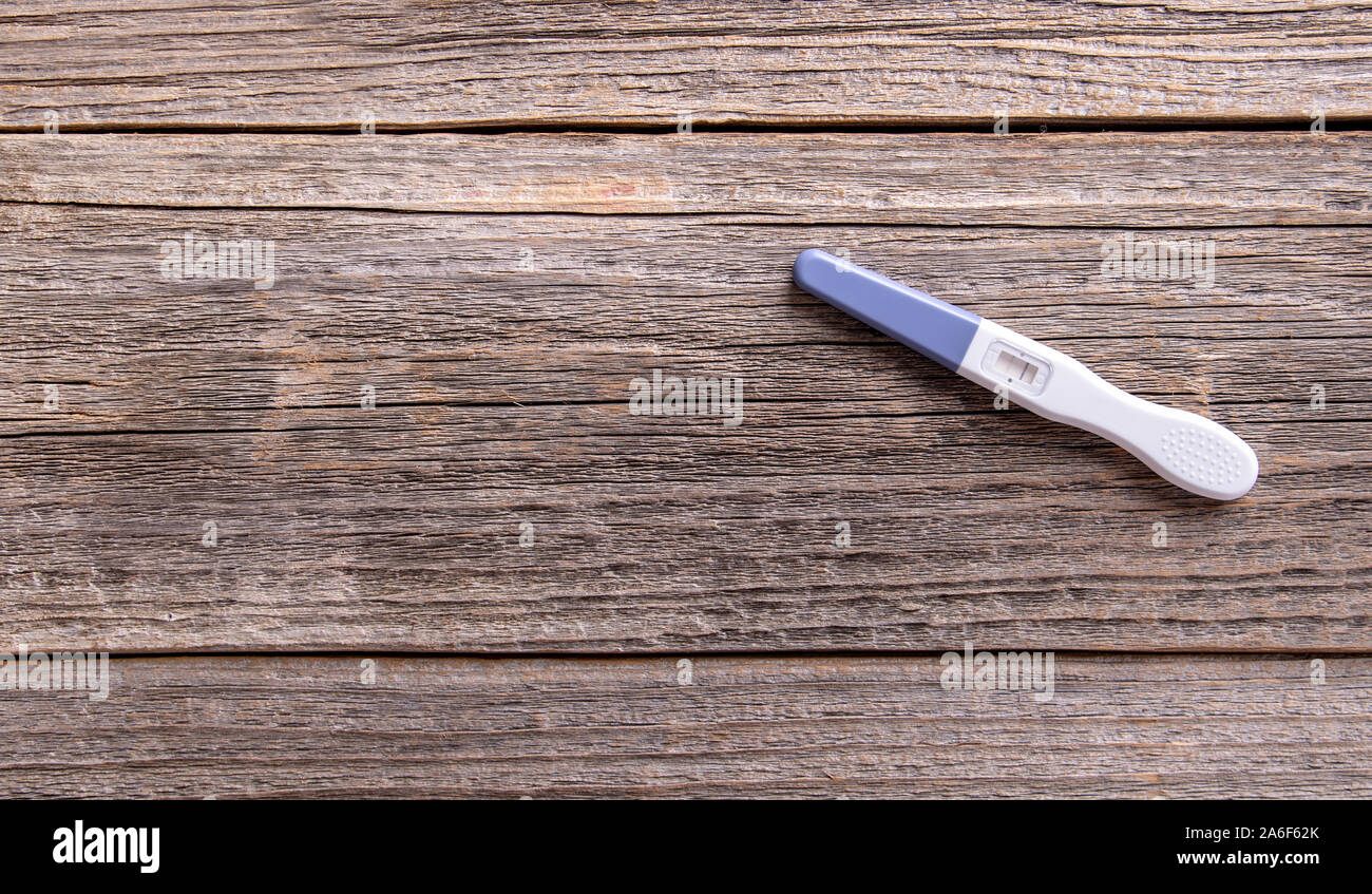 Test di gravidanza come una vita ancora su un sfondo di legno. Foto Stock