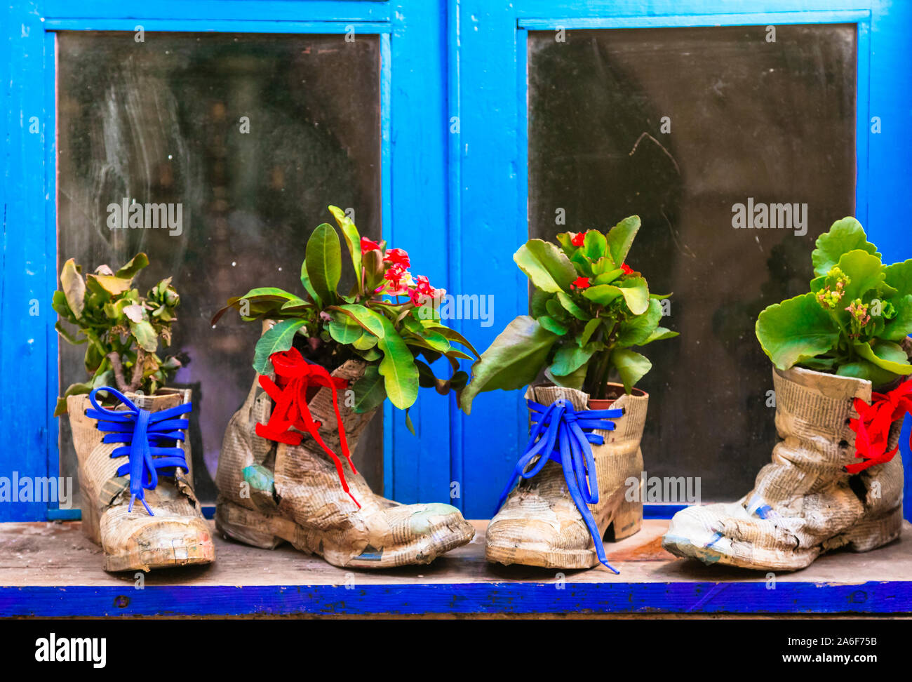 Vecchie strade di villaggio italiano,vista con vecchie scarpe e decorazioni floreali. Foto Stock