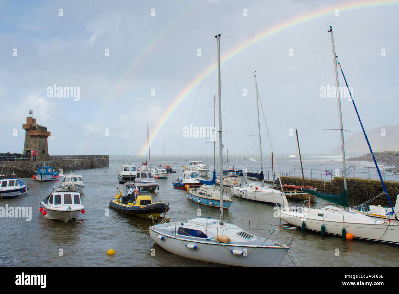 Rainbow sul mare, barche, porto e operazioni automatiche di fine campo a Lynmouth durante le tempeste, Devon, Regno Unito, Settembre. Alta Marea, Foto Stock