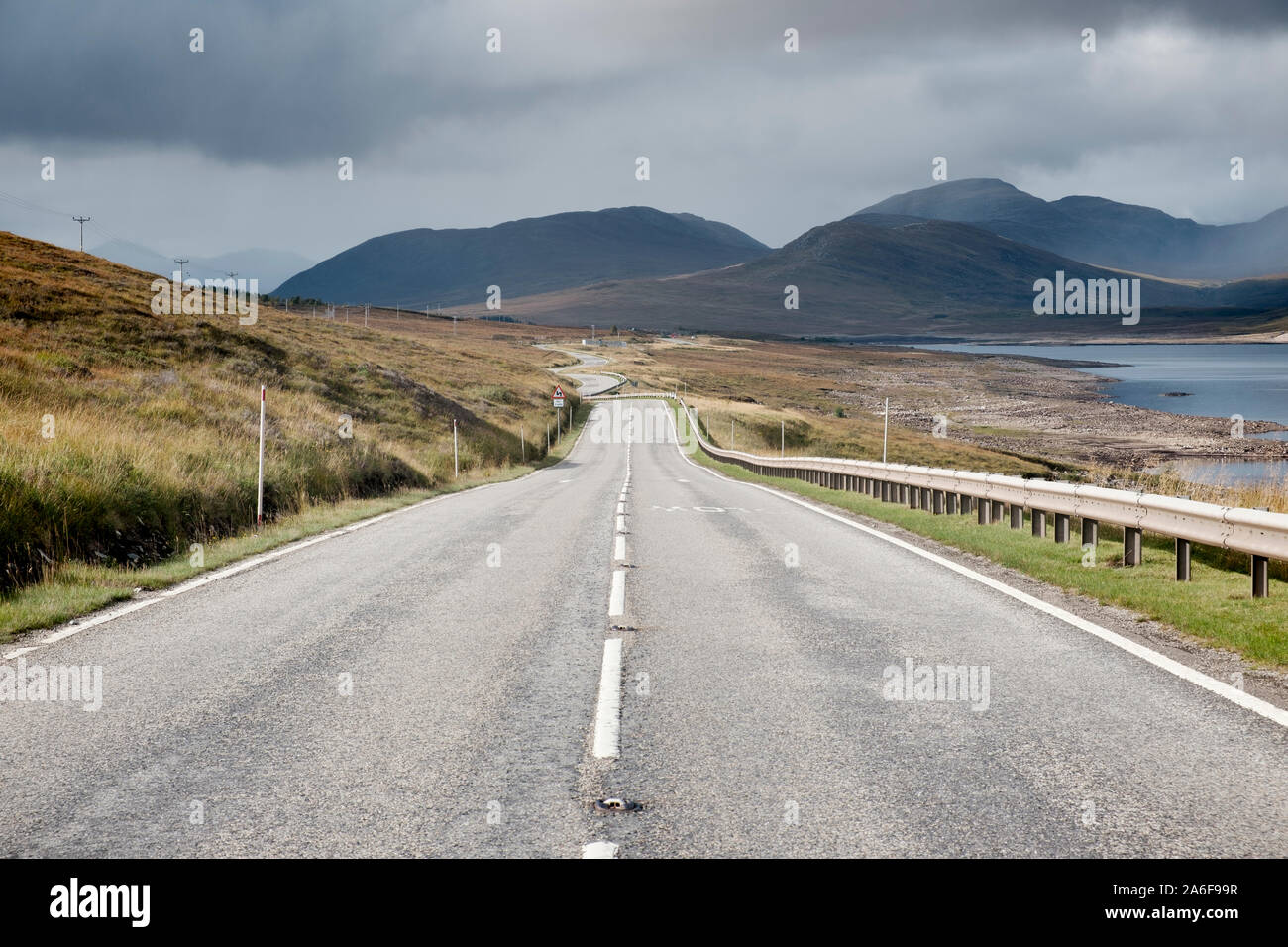 Lungo tratto rettilineo di vuoto strada che conduce alla montagna in Sutherland nelle Highlands scozzesi Foto Stock