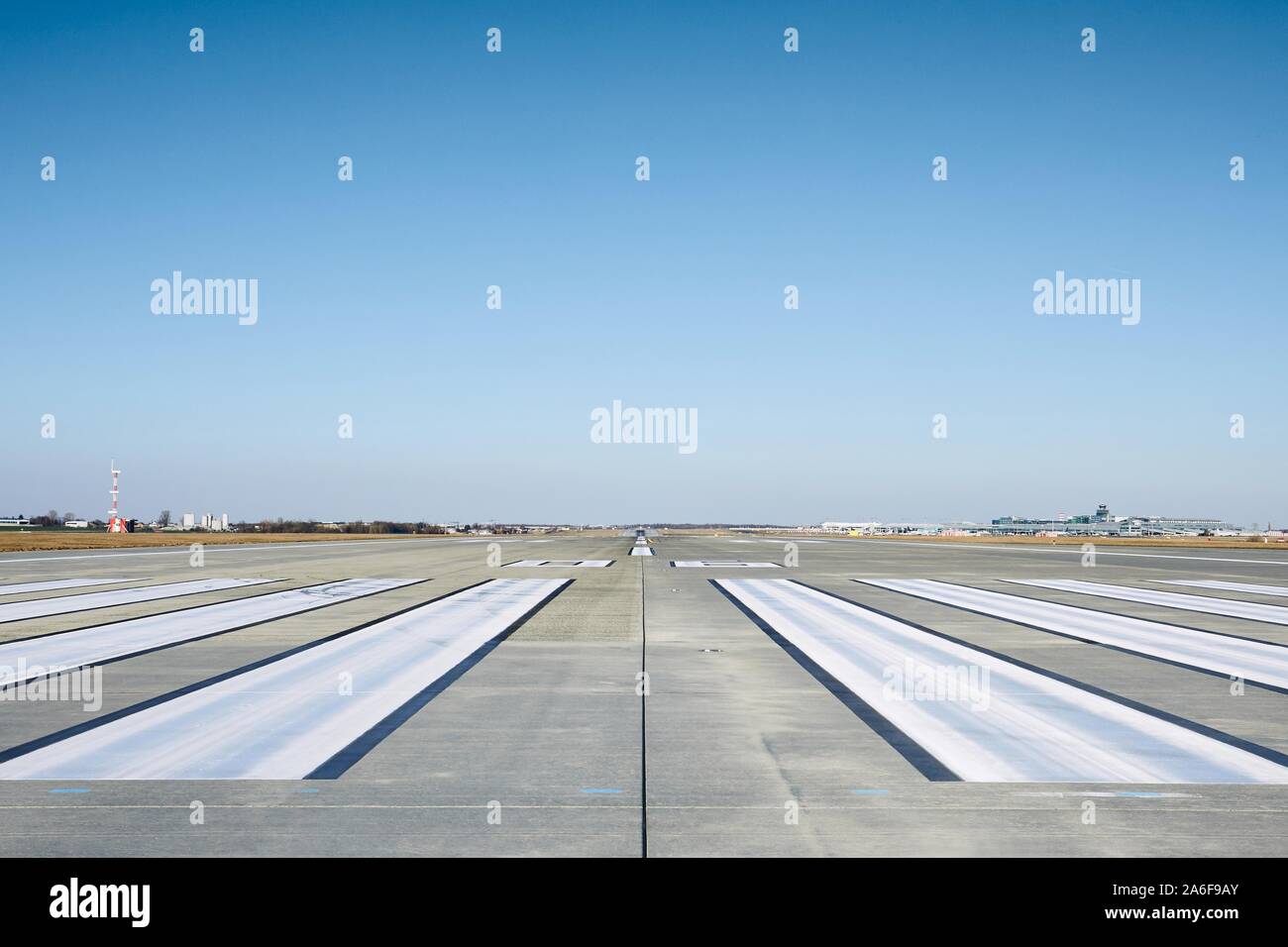 Livello di superficie della pista di aeroporto con la segnaletica stradale contro il cielo chiaro. Foto Stock