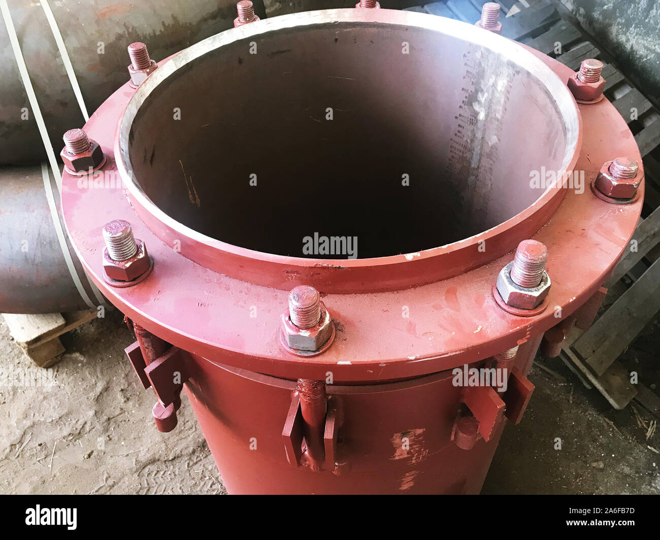 Premistoppa rosso di giunti di dilatazione per principale di riscaldamento sul pavimento di cemento. Il calore e la nozione di potenza. Foto Stock