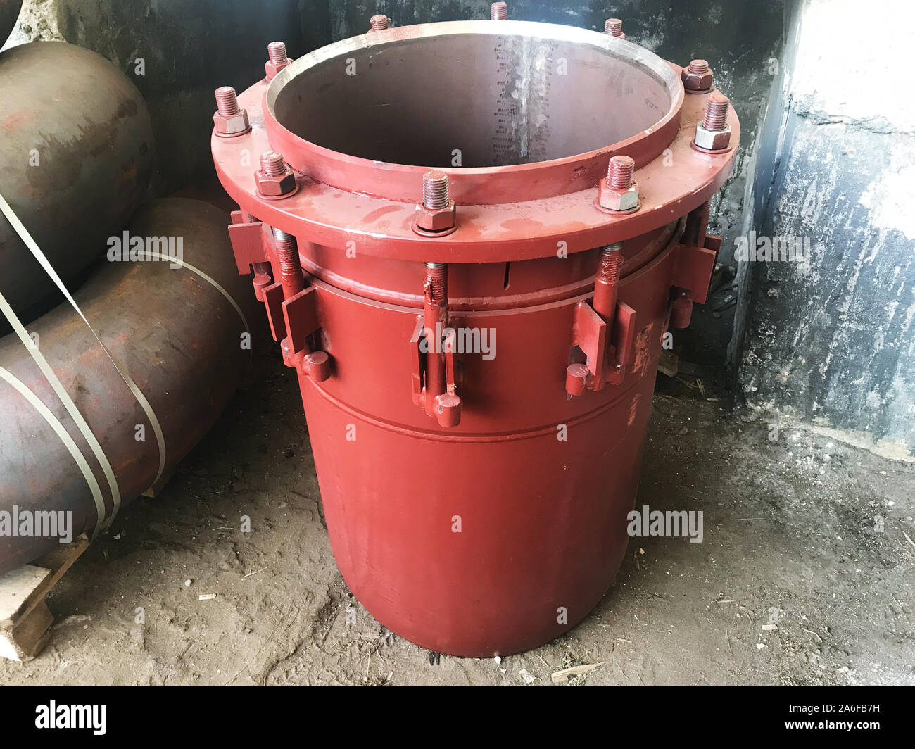 Premistoppa rosso di giunti di dilatazione per principale di riscaldamento sul pavimento di cemento. Il calore e la nozione di potenza. Foto Stock