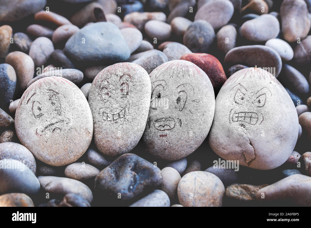 La gestione di emozioni facce emoji su pietre - triste, felice, sorpreso preoccupata e arrabbiato sentimenti disegnare Foto Stock