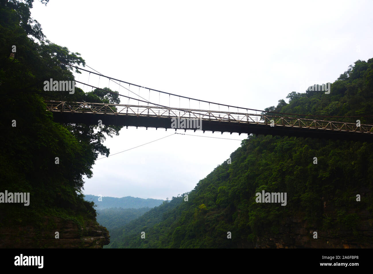 La sospensione ponte di sospensione di Umngot nel fiume Dawki, Shillong, Meghalay vicino al confine India-Bangladesh come visto da sotto il fiume Foto Stock