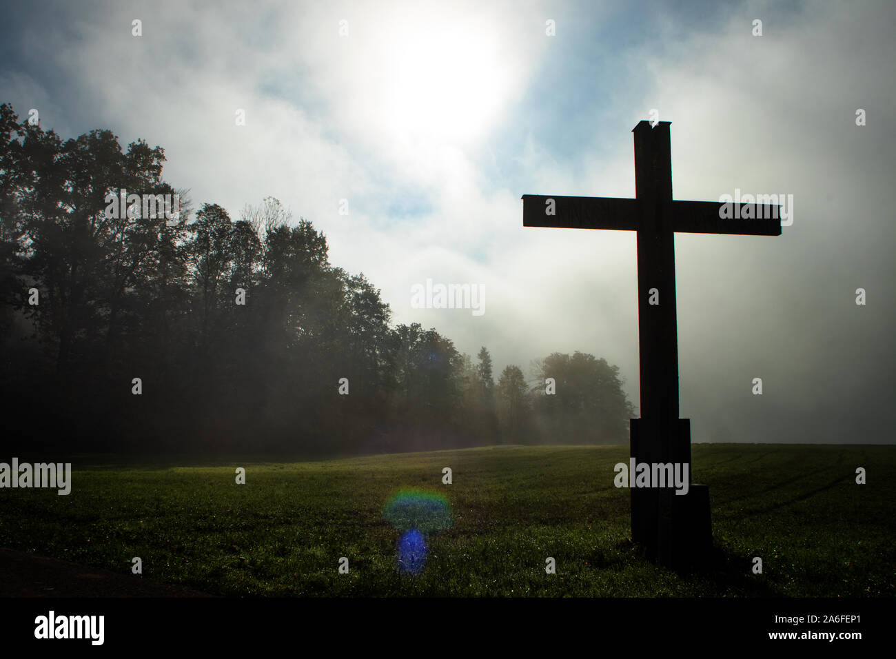 Croce nel paese durante una nebbia morging mistica e impostazione Foto Stock