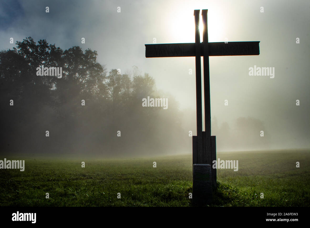 Croce nel paese durante una nebbia morging mistica e impostazione Foto Stock