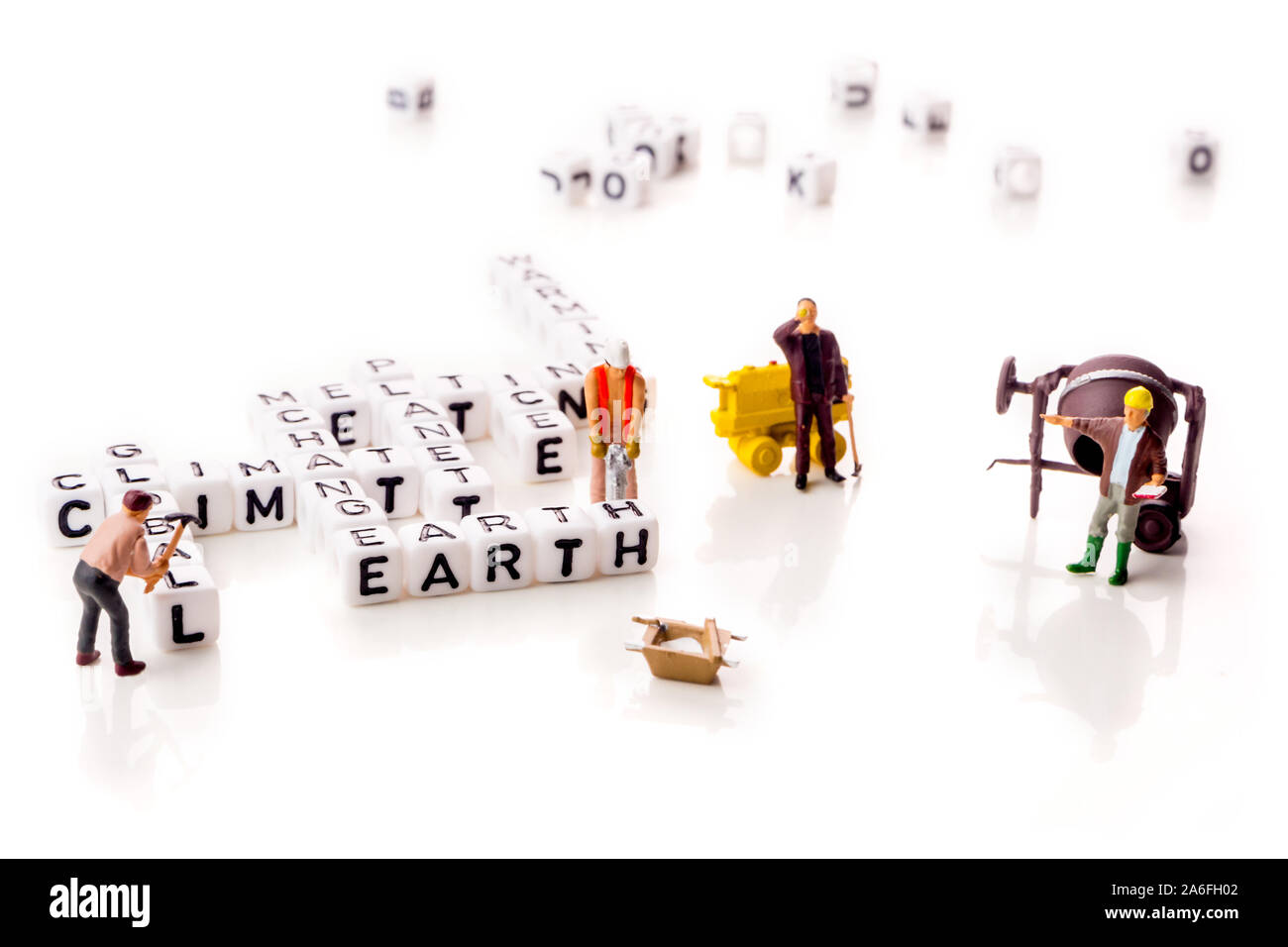 Il cambiamento climatico globale con planet di riscaldamento e fusione del ghiaccio parole in forma di cubetti di bianco con i lavoratori in miniatura figurine con lettere in nero su bianco b Foto Stock