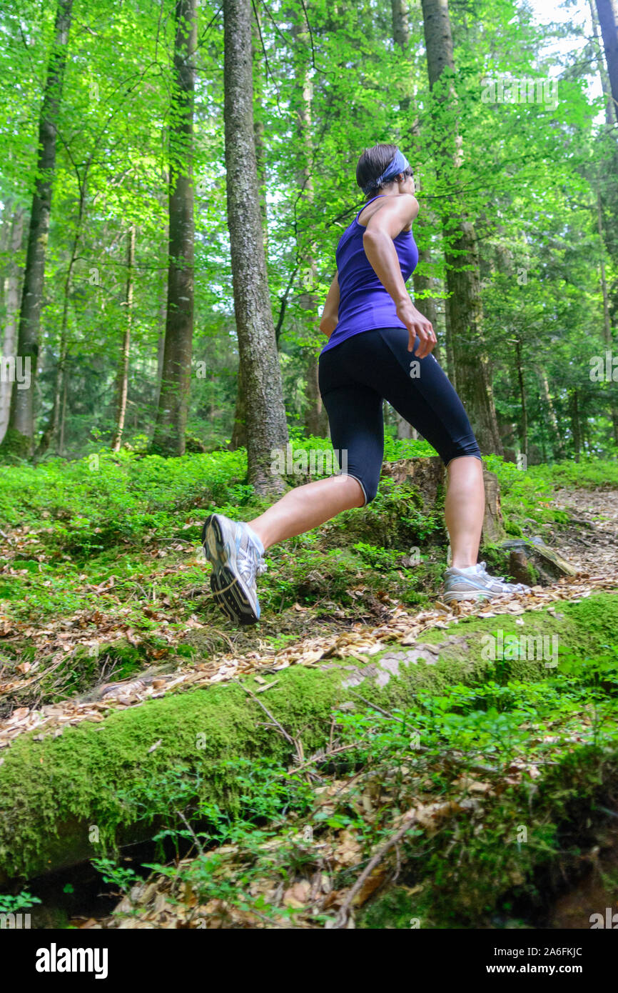 Giovane jogging nella foresta - faticoso allenamento in estate Foto Stock