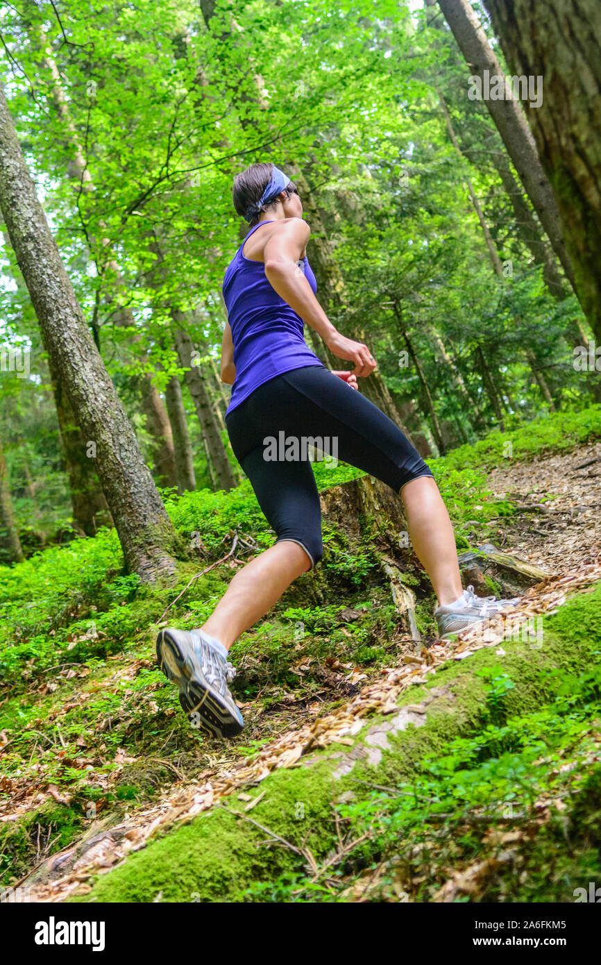 Giovane jogging nella foresta - faticoso allenamento in estate Foto Stock