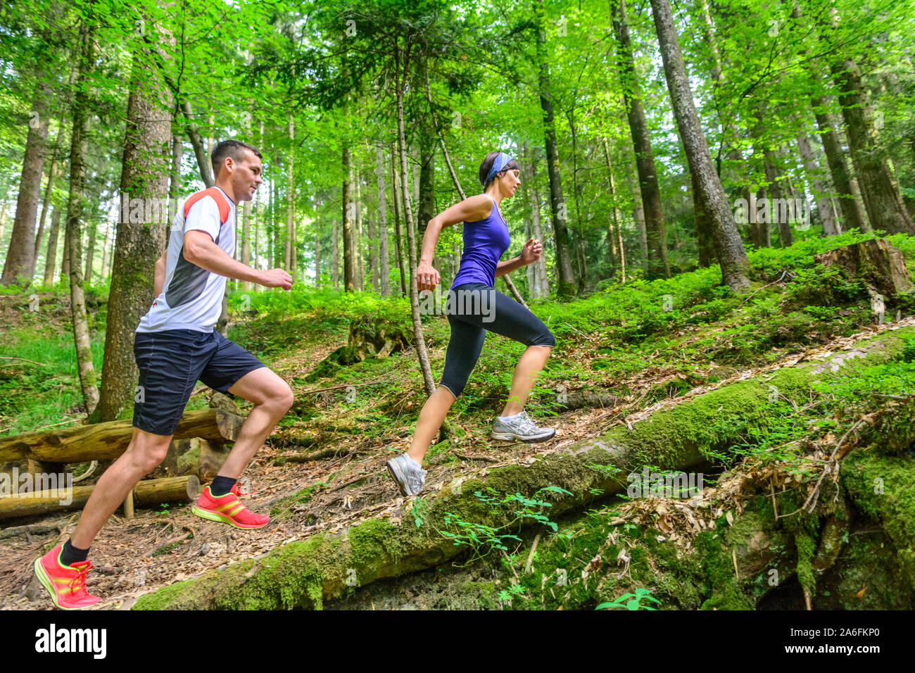Coppia giovane jogging nella foresta - faticoso allenamento in estate Foto Stock