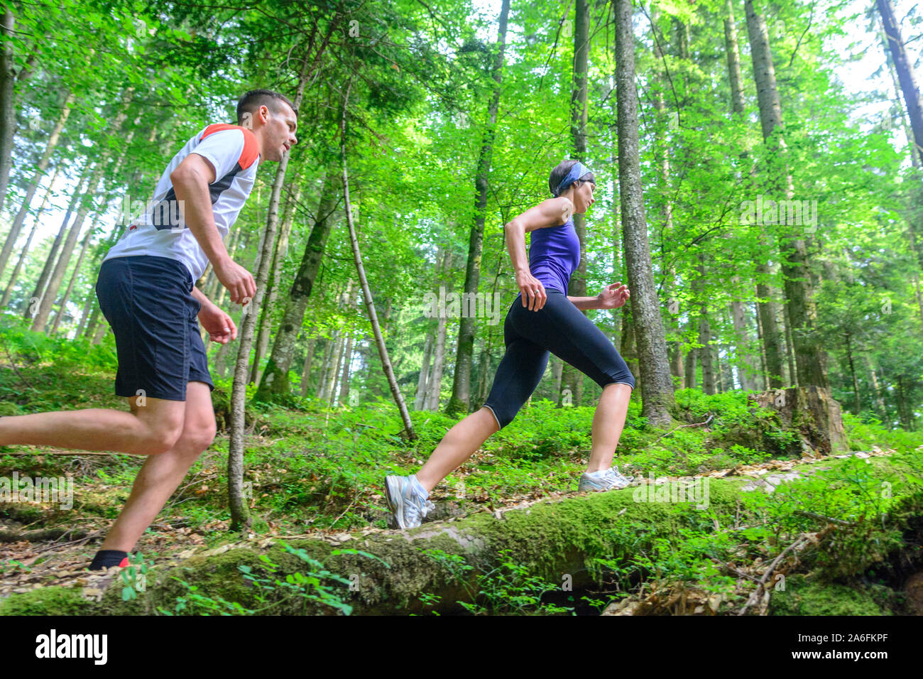 Coppia giovane jogging nella foresta - faticoso allenamento in estate Foto Stock