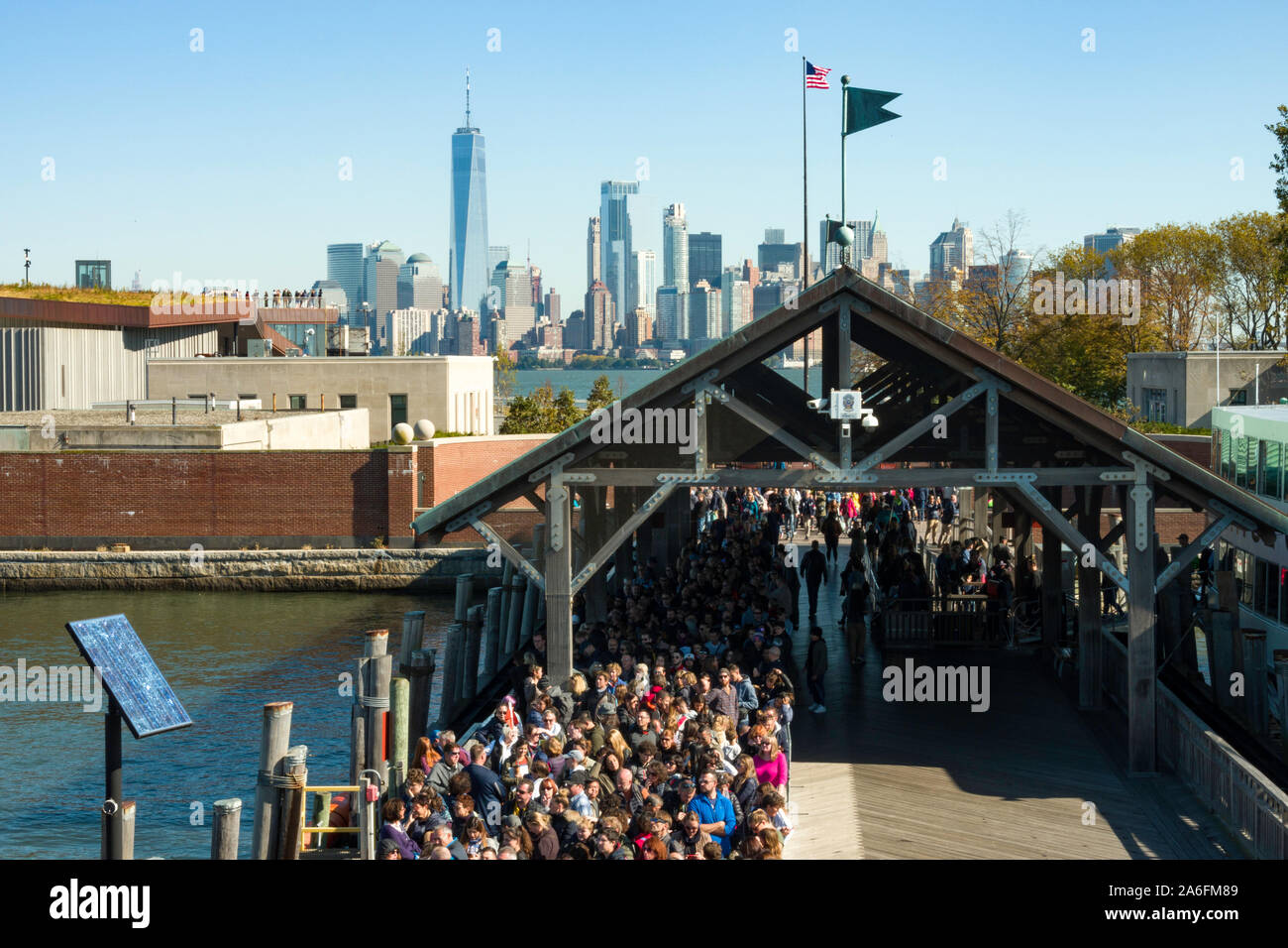 I visitatori della Statua della Libertà Parco Nazionale di attendere in linea per prendere il traghetto, NYC, STATI UNITI D'AMERICA Foto Stock