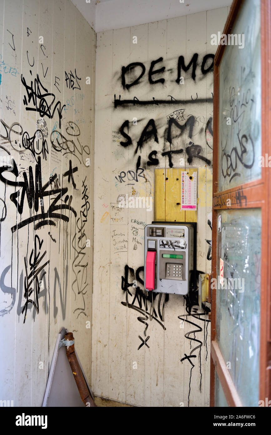 Pubblico in legno pagare cabina telefonica con telefono e coperto di graffiti sulle pareti in Parenzo in Istria, Croazia Foto Stock
