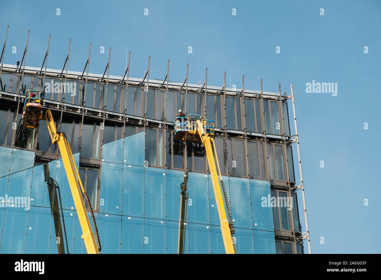 Gru sulla facciata di vetro ufficio edificio in costruzione Foto Stock