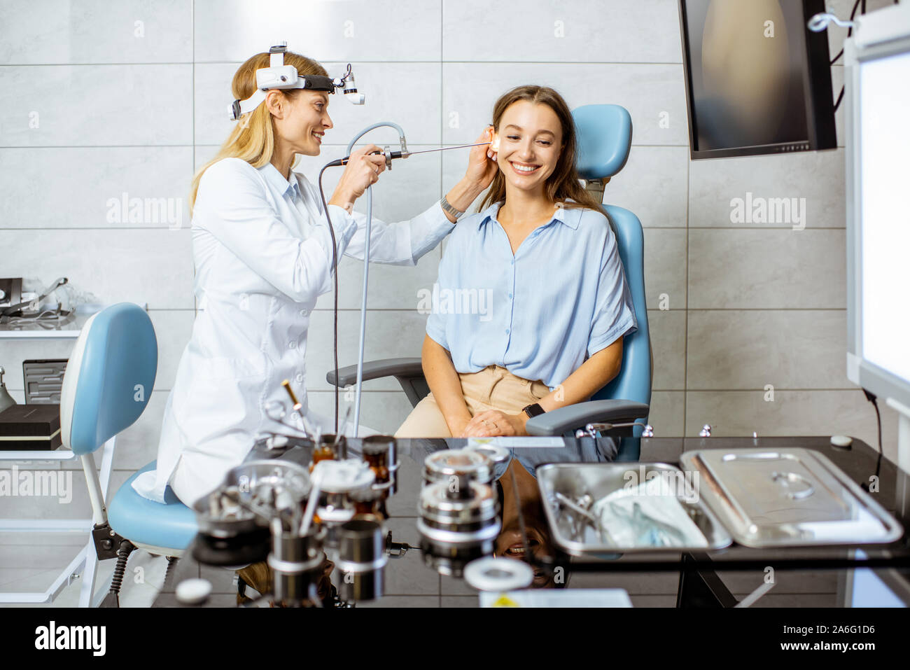 Senior otolaryngologist rendendo esame endoscopico di un orecchio per un giovane paziente presso l ufficio ENT Foto Stock