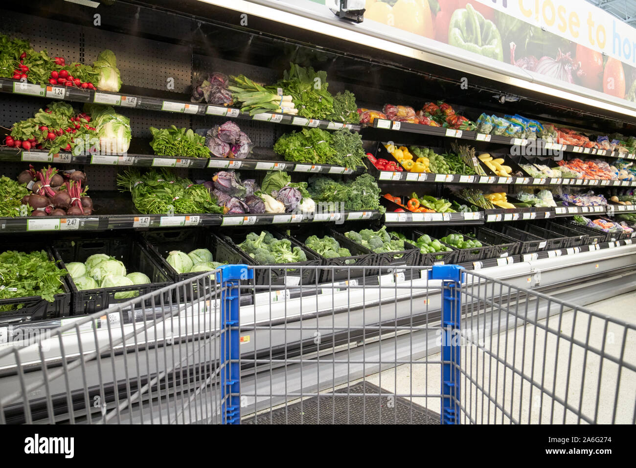 Carrello di spinta attraverso walmart superstore verdura fresca corsia indiana USA Foto Stock