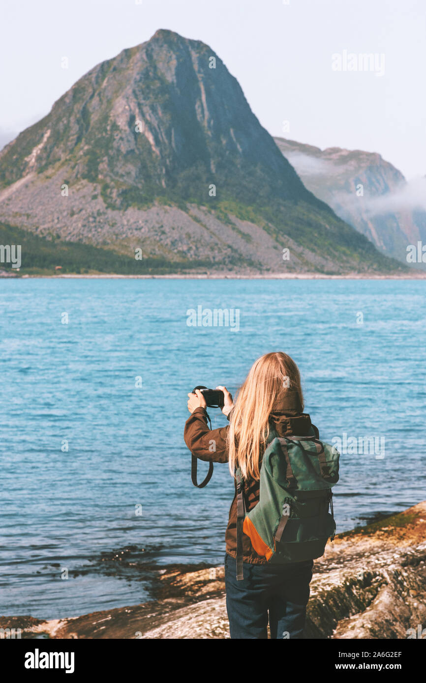Donna traveler prendendo foto dalla fotocamera ad esplorare la Norvegia fiordi viaggio d avventura vacanze estive in viaggio lifestyle Foto Stock