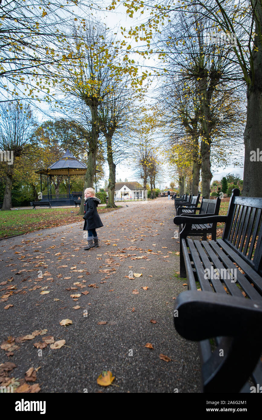 Una bambina gode di una passeggiata nel castello di Colchester Park in Essex su una bella giornata d'autunno Foto Stock