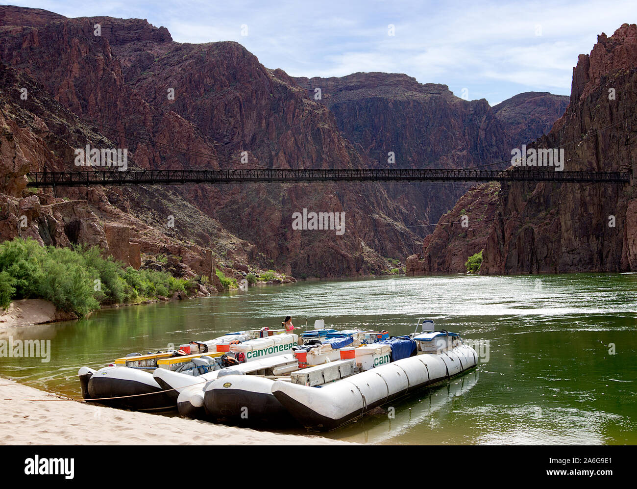 White water rafting in spiaggia in barca con ponte nero in background sul Fiume Colorado nel Grand Canyon sul fiume Colorado Foto Stock