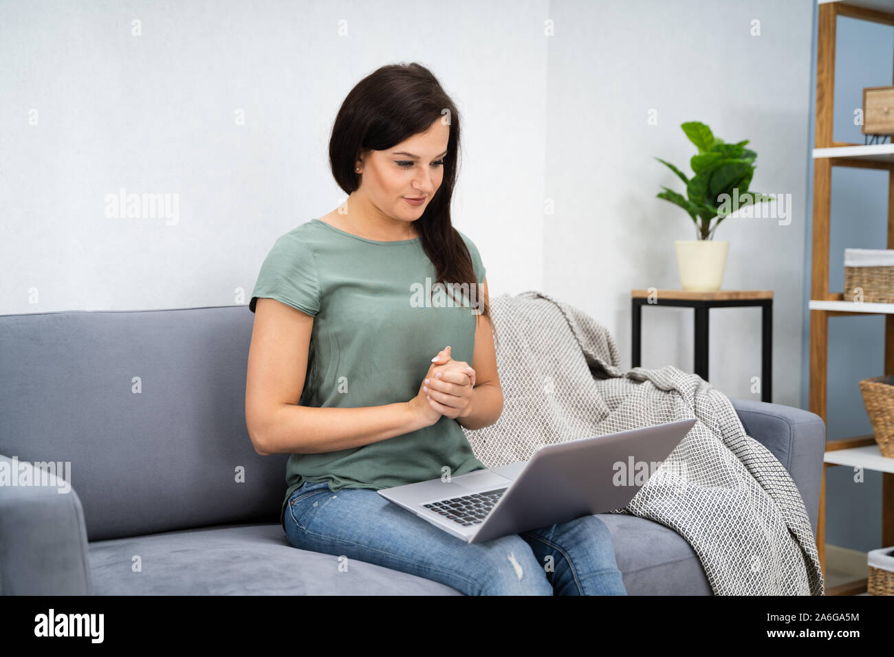 La donna la videoconferenza su laptop al salotto di casa Foto Stock