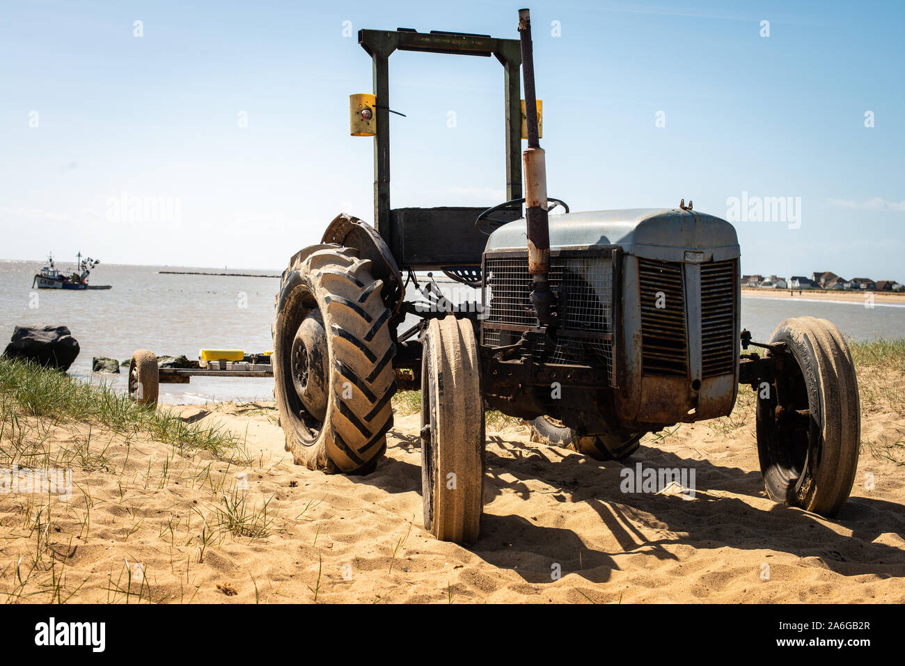 Un vecchio arrugginito e alterò il trattore sulla spiaggia, utilizzati per il trasporto di imbarcazioni in e fuori del mare per la pesca e gite in barca, Jaywick, Clacton On Sea, Foto Stock