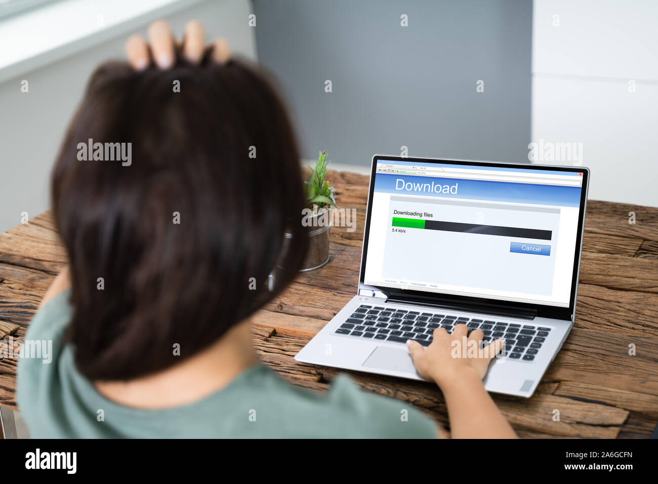 Sottolineato Donna che guarda la lenta velocità di download su uno schermo del notebook Foto Stock