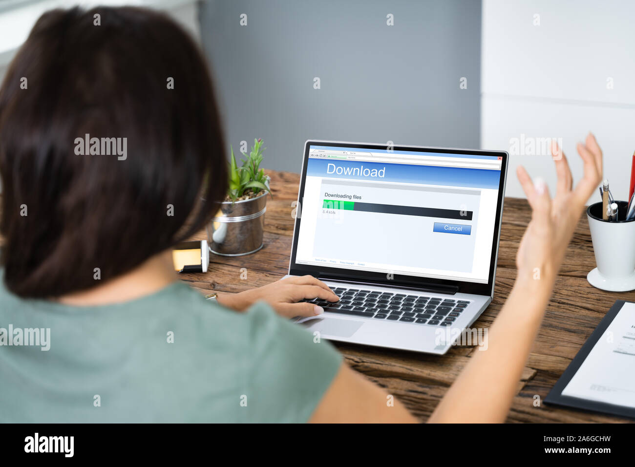 Sottolineato Donna che guarda la lenta velocità di download su uno schermo del notebook Foto Stock