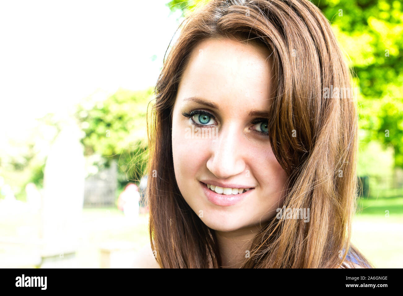 Una bella ragazza in posa per una foto in un bellissimo vestito blu su di una splendida giornata d'estate Foto Stock