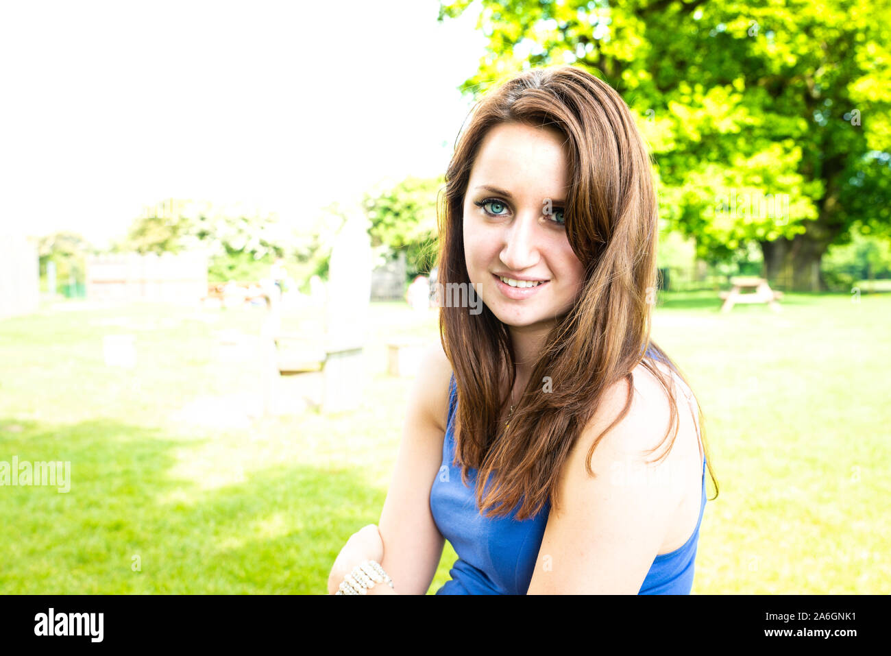 Una bella ragazza in posa per una foto in un bellissimo vestito blu su di una splendida giornata d'estate Foto Stock