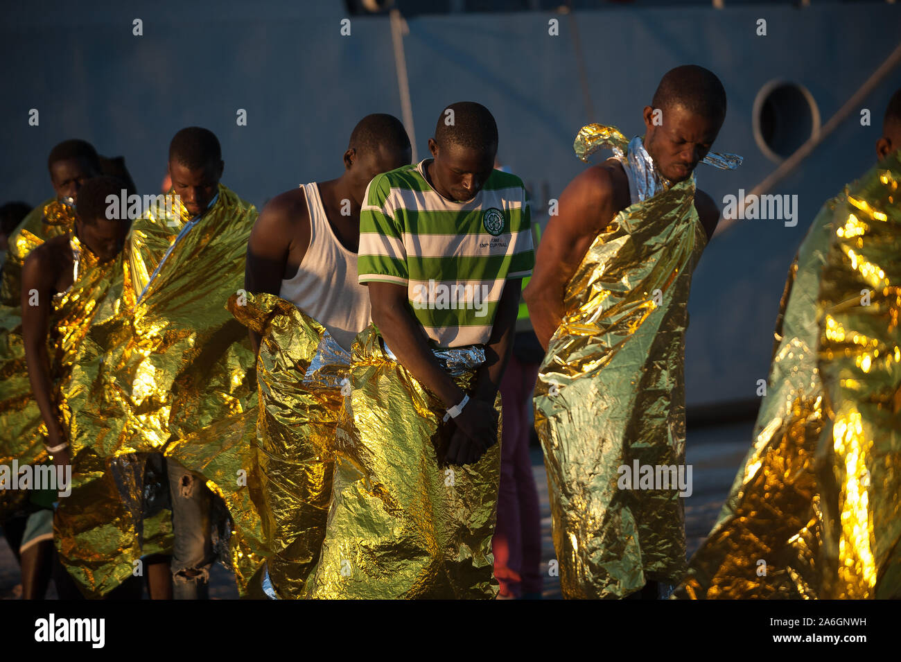 Subsahariana i migranti in una coda di sbarco da una nave pattuglia coperti  con coperte termiche dopo il salvataggio.La nave di Jean Francois Deniau,  un francese di Frontex nave pattuglia intercettato 56