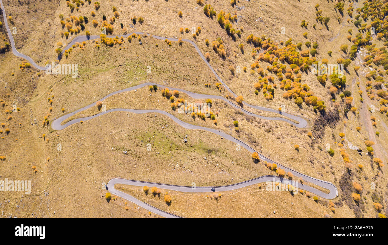 Strada per il Gavia mountain pass in Italia. In alto e in basso incredibile vista aerea della montagna si piega creando splendide forme. Tempo di caduta. Colori caldi Foto Stock