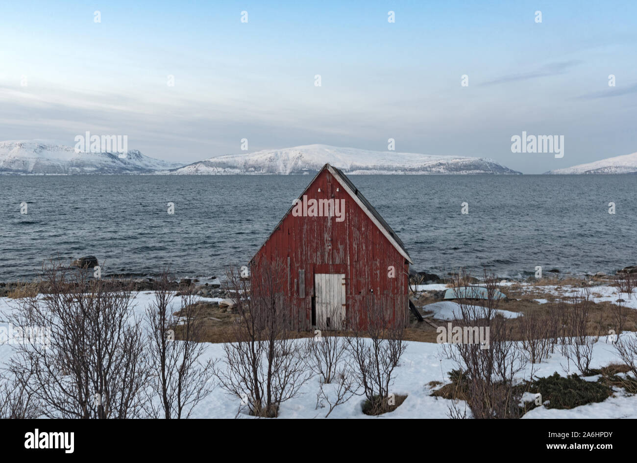 Old red boathouse presso la riva del Ullsfjord nella contea di Troms in Norvegia Foto Stock