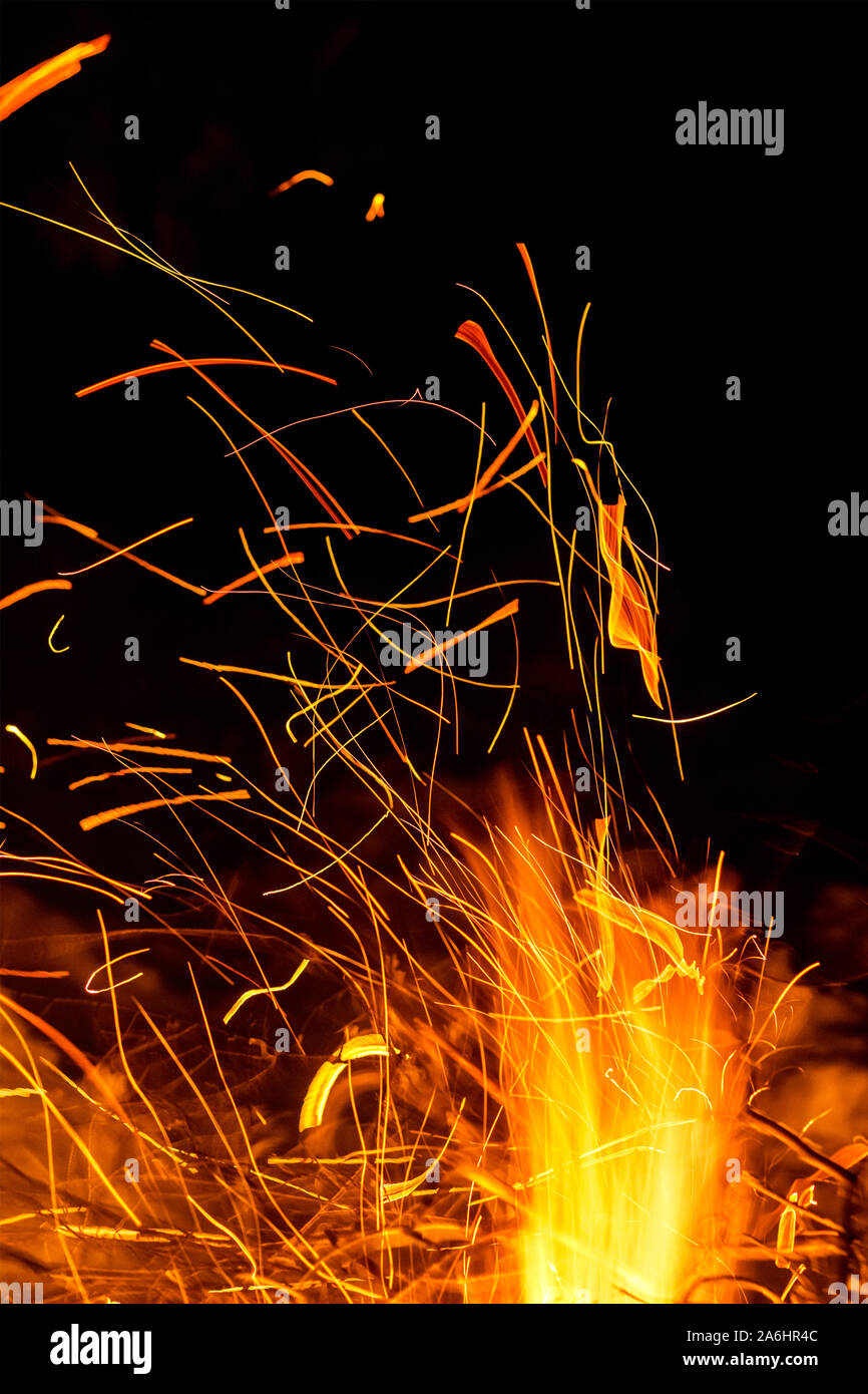La formazione di scintille dal fuoco in movimento sfocato. Notte sfondo luminoso Foto Stock