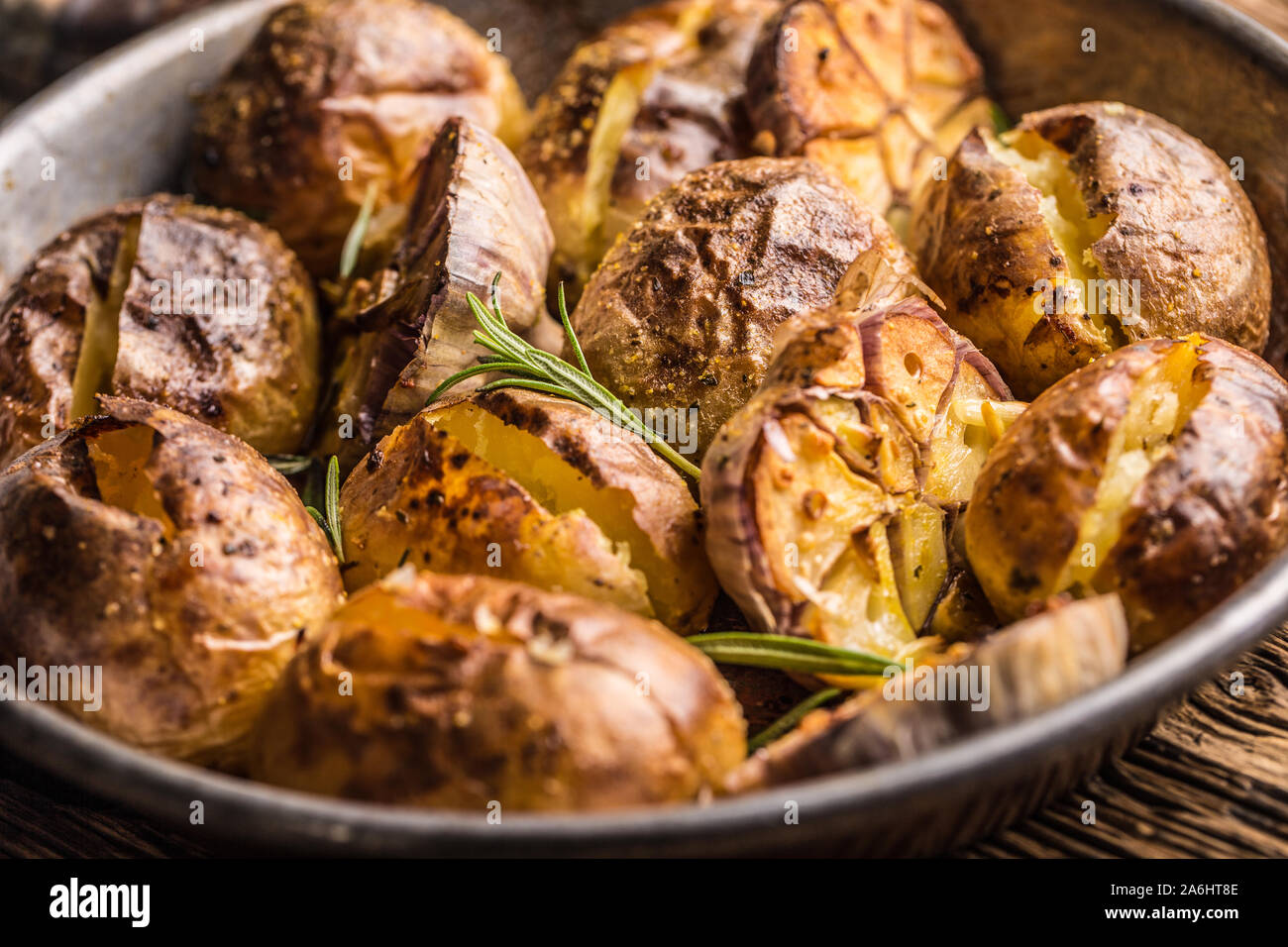 Patate arrosto con aglio spezie ed erbe in padella vintage Foto Stock