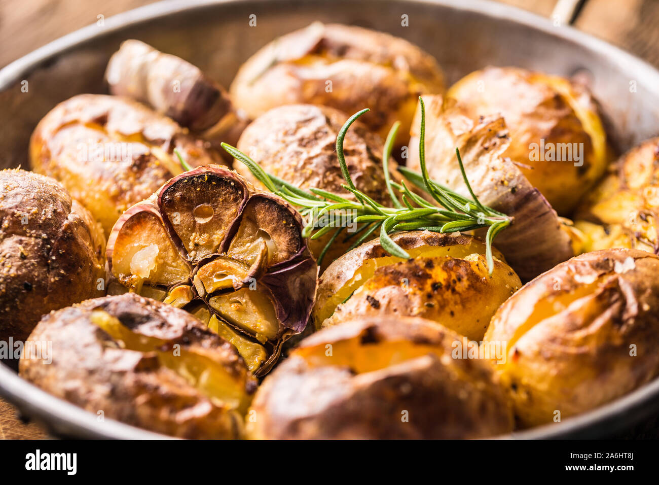 Patate arrosto con aglio spezie ed erbe in padella vintage Foto Stock