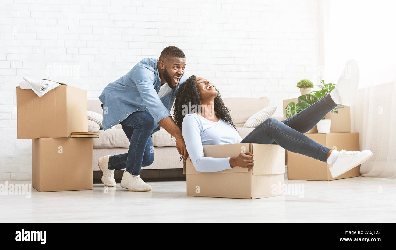 Sper uomo felice spingendo box con la sua donna in movimento Foto Stock